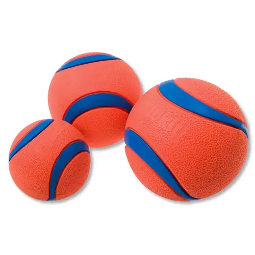 Chuckit! Ultra Ball in drie maten naast elkaar, oranje rubber