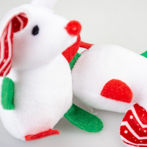 Close-up van een witte pluche kerstmuis met rood bolneusje en groene vilten pootjes
