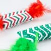 Close-up van het pluche kussentje met rode en groene zigzagprint en veren