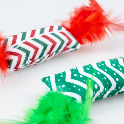 Close-up van het pluche kussentje met rode en groene zigzagprint en veren