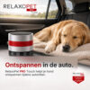 RelaxoPet PRO Touch in de auto naast een slapende hond op een reisdeken