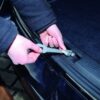 Handen die Car Cooler 10cm klem monteren aan kofferbakklep van zwarte auto voor ventilatie hond