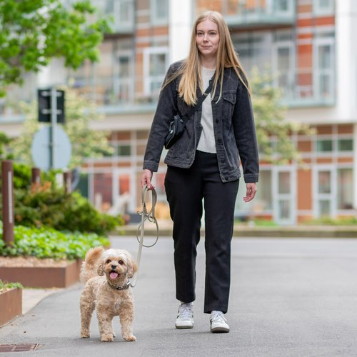 DOG Copenhagen Urban Classic hondenlijn – vrouw loopt met kleine krullende hond aan lijn in stadsstraat
