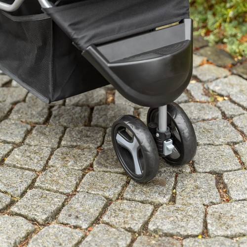 Dubbel geveerd voorwiel van de hondenbuggy met spatbord op de klinkers