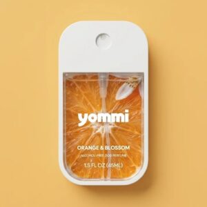Yommi hondenparfum Orange & Blossom, witte flacon van 45 ml met sinaasappelschijf op het etiket, okergele achtergrond