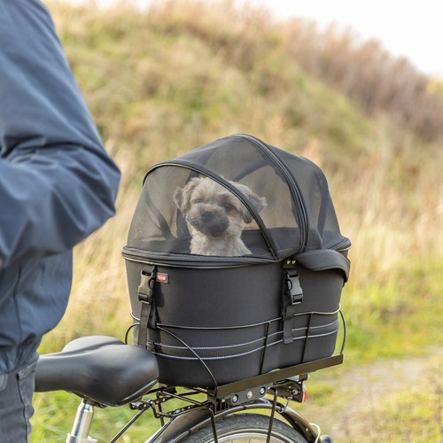 Hond veilig onder de gesloten gaaskoepel van de fietsmand