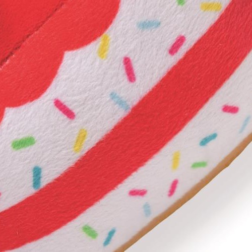 Detail van de rood witte lagen met gekleurde sprinkels op de pluche taart