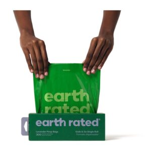 Handen trekken een hondenpoepzakje uit de Earth Rated poepzakjesdoos