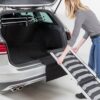 Vrouw legt de loopplank tegen de laadrand van de kofferbak